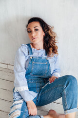 portrait of a beautiful blonde woman in a denim jumpsuit