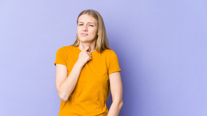 Young blonde woman isolated on purple background suffers pain in throat due a virus or infection.