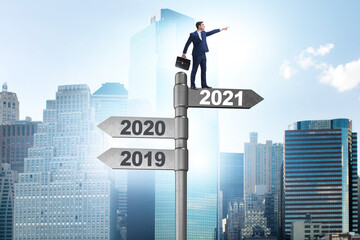Road sign and businessman with 2020 and 2021