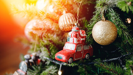 Christmas tree decorated with illumination and toys, red car with gifts on roof is symbol of travel and trip