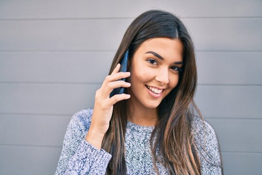 Young beautiful hispanic girl smiling happy talking on the smartphone at the city.