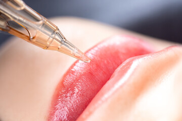 Macro photo of process of applying permanent makeup tattoo of red on lips woman - obrazy, fototapety, plakaty