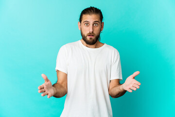 Obraz premium Young man with long hair look surprised and shocked.