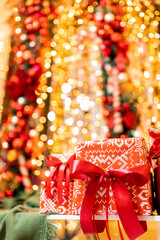 Naklejka premium Christmas gift boxes with red ribbon on bokeh blur lights and illumination background