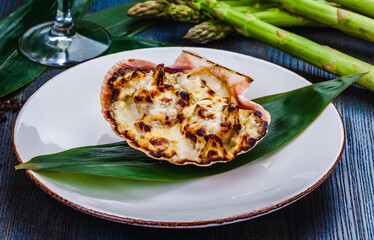 Scallop baked with cheese served in a shell