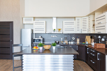 Contemporary ordinary design of spacious studio in soft warm colors. Simple furniture. Light large room with sunlight. Daytime. Tiled brown floor and white walls .