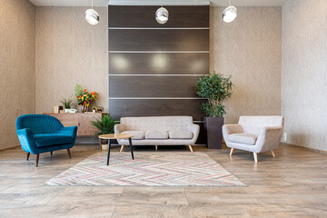 Contemporary ordinary design of spacious studio in soft warm colors. Simple furniture. Light large room with sunlight. Daytime. Tiled brown floor and white walls .