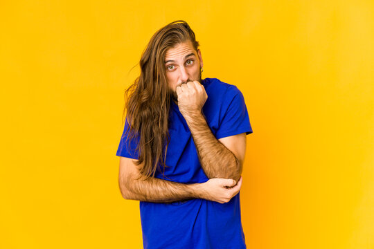 Young Man With Long Hair Look Biting Fingernails, Nervous And Very Anxious.