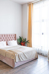 Contemporary ordinary design of spacious studio in soft warm colors. Simple furniture. Light large room with sunlight. Daytime. Tiled brown floor and white walls .