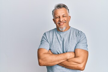 Middle age grey-haired man wearing casual clothes happy face smiling with crossed arms looking at the camera. positive person.