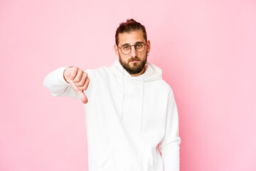 Young man with long hair look showing a dislike gesture, thumbs down. Disagreement concept.