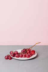 Still life of a bunch of grapes on a pink background