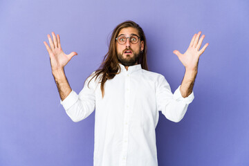 Young man with long hair look celebrating a victory or success, he is surprised and shocked.