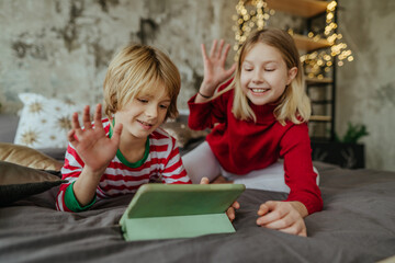 Boy and girl using tablets in Christmas time
