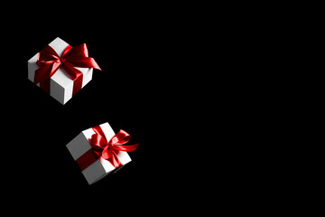 Shopping gift. White gift box with red ribbon isolated on black background in Black Friday concept. Winter flying composition with copy space.