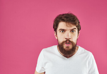 Obraz premium Emotional man gesturing with his hands on a pink background Copy Space