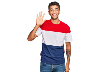 Young handsome african american man wearing casual clothes showing and pointing up with fingers number five while smiling confident and happy.