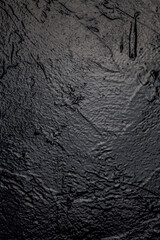 Old black paint vintage wall structure the texture of stone as a background