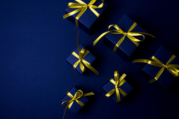 Navy blue gifts with gold ribbons.Set of gift box isolated on navy blue background.Christmas gift boxes on black background. Merry Christmas and Happy Holidays greeting card, frame, banner. 