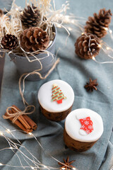 Christmas decorated sweet pastry on teal background, pine cones, cinnamon and anise stars as eco decoration