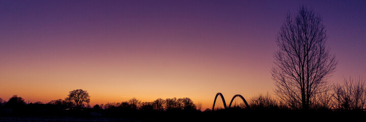 Fototapeta na wymiar Panorama of landscape silhouette with bridge of munsterland at dusk