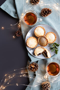 Mince Pies On A Plate And Cups With Black Tea Shot From Above With Copy Space. A Mince Pie Is A Traditional Christmas Sweet Pie, Filled With A Mixture Of Dried Fruits And Spices