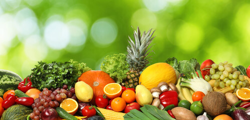 Naklejka na ściany i meble Assortment of fresh organic vegetables and fruits on blurred green background. Banner design