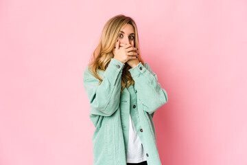 Young caucasian blonde woman shocked covering mouth with hands.