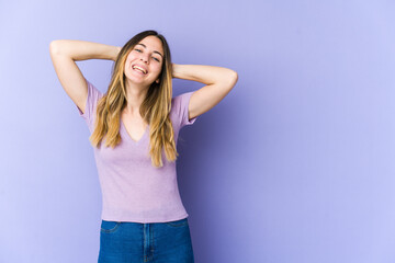 Fototapeta premium Young caucasian woman isolated on purple background stretching arms, relaxed position.