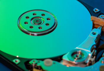 Macro photography  of hard drive internal mechanism hardware selective focus, in green blue light