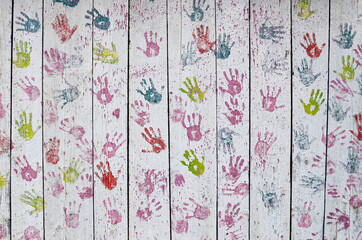 Multicolored kids handprints on white background.