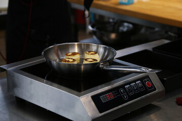 cooking cottage cheese pancakes in a skillet in the kitchen