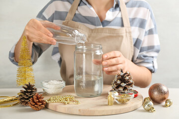 Woman making snow globe at light table, closeup