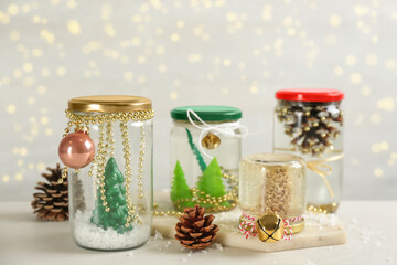 Handmade snow globes and fir cones on light table