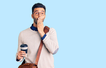 Young handsome hispanic man wearing leather bag and drinking take away coffee covering mouth with...