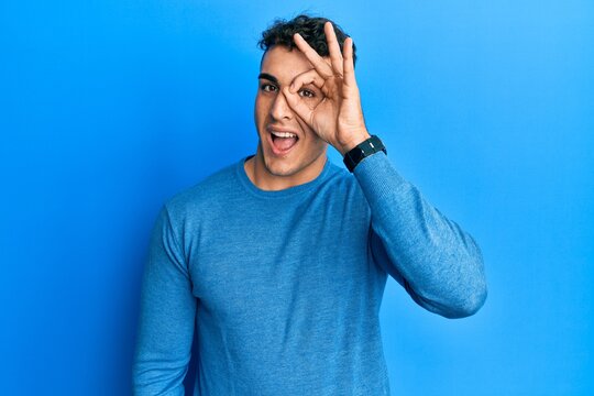 Handsome young man wearing casual clothes looking fascinated with disbelief, surprise and amazed expression with hands on chin