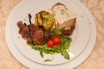 neck with mushroom sauce, duck confit, potatoes with broccoli and valerian with tomatoes