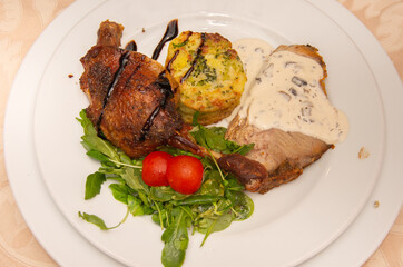 neck with mushroom sauce, duck confit, potatoes with broccoli and valerian with tomatoes