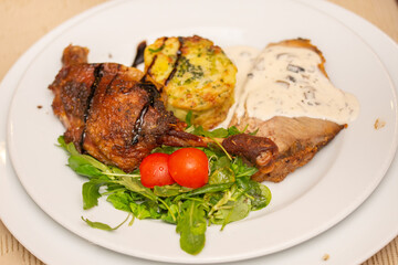 neck with mushroom sauce, duck confit, potatoes with broccoli and valerian with tomatoes