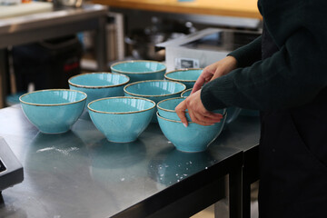 blue plates on metal table in restaurant kitchen