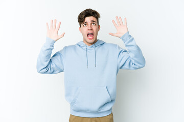 Young caucasian man isolated on white background screaming to the sky, looking up, frustrated.