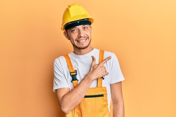 Young hispanic man wearing architect hardhat surprised with hand on head for mistake, remember error. forgot, bad memory concept.