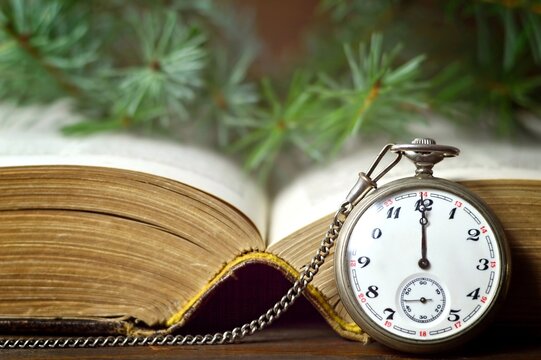 Christmas midnight pocket watch and old book. Midnight countdown