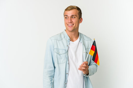 Young Caucasian Man Holding A German Flag Isolated On White Background