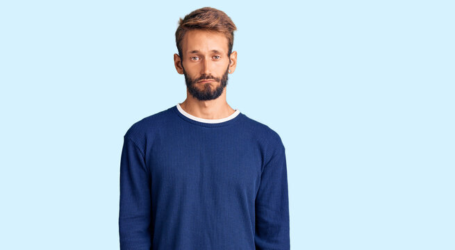 Handsome blond man with beard wearing casual sweater depressed and worry for distress, crying angry and afraid. sad expression.