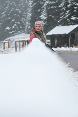 A young smiling woman is looking forward to the snow