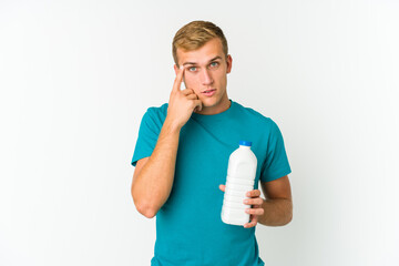 Young caucasian man drinking milk isolated on white background