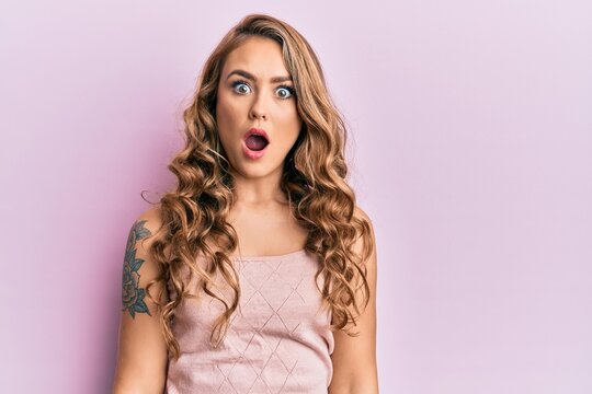 Young blonde girl wearing casual clothes afraid and shocked with surprise expression, fear and excited face.