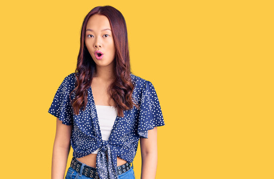Young beautiful chinese girl wearing casual clothes afraid and shocked with surprise expression, fear and excited face.