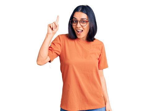 Young beautiful latin woman wearing casual clothes pointing finger up with successful idea. exited and happy. number one.